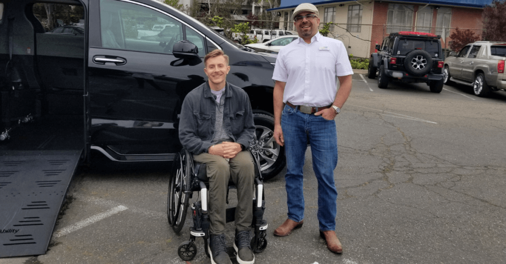 Two men inn front of a wheelchair accessible vehicle